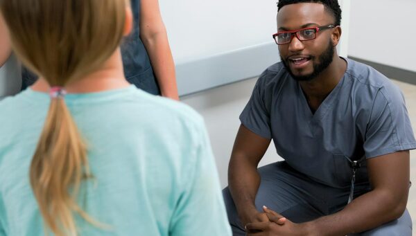 Male nursing student engages in discussion with other Excelsior University students